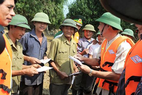 Đoàn công tác tỉnh Thanh Hoá đến trao tiền mỗi suất 200 ngàn đồng cho các hộ dân 3 xóm ở xã Hưng Lam, huyện Hưng Nguyên, tỉnh Nghệ An - Ảnh: SỸ MINH