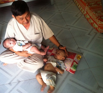 Cư sĩ Nguyễn Văn Lâm chăm sóc giấc ngủ cho các bé sơ sinh. Ảnh: PHƯƠNG NAM