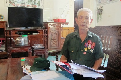 Ông Nguyễn Tiến Hồng với tập hồ sơ đi kiện lâu nay. Ảnh: HOÀNG THÔNG